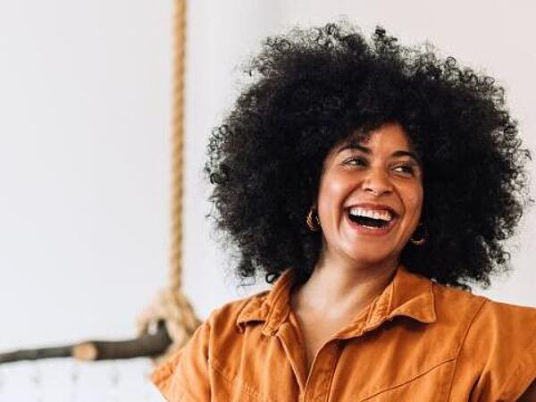Cover image from The New Consumer Reality whitepaper showing a smiling woman standing beside a laptop in a retail setting.