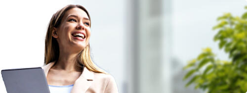 Person holding a laptop in a bright outdoor setting for Statista+ Communication Services